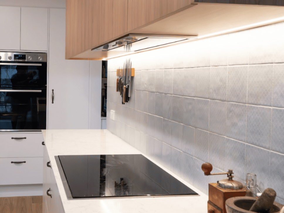 Compact kitchen with timber upper cabinets, white cabinetry and grey splashback